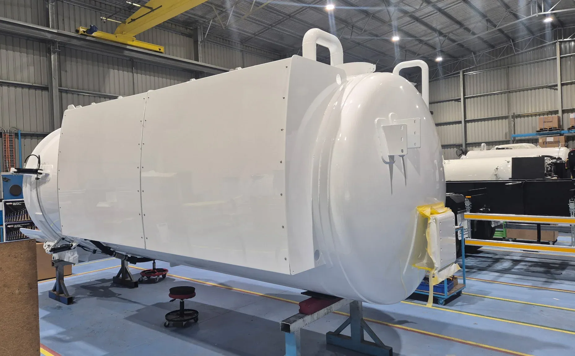 Painted vacuum tank barrel on stands on the factory floor