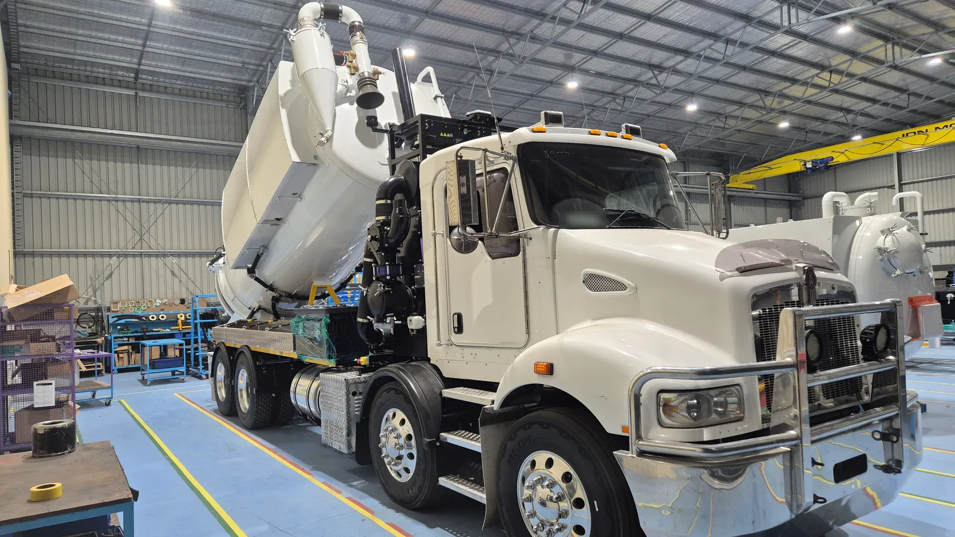 Vacuum unit mounted on the truck chassis on the factory floor, tank raised