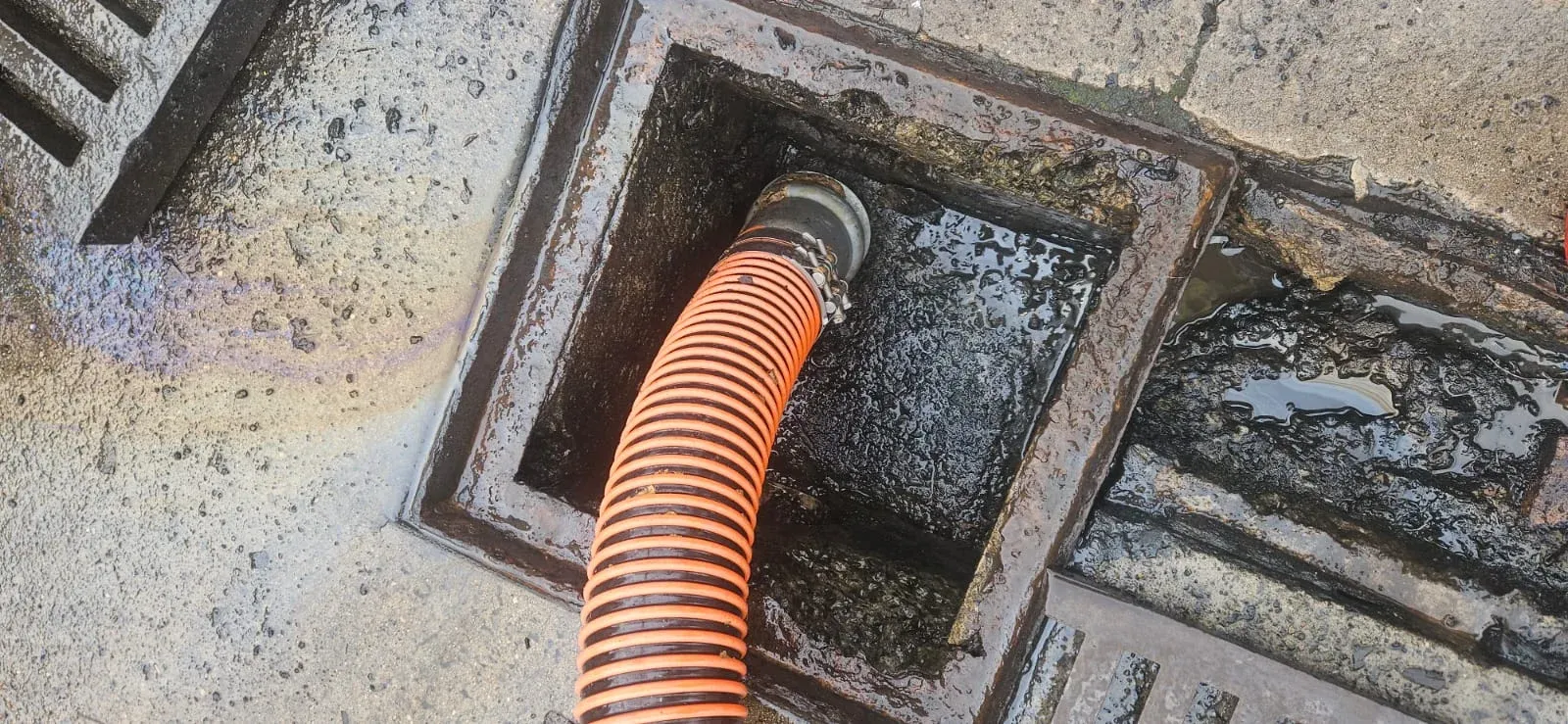ASB Vac Services suction hose actively extracting liquid waste from a Sydney stormwater pit