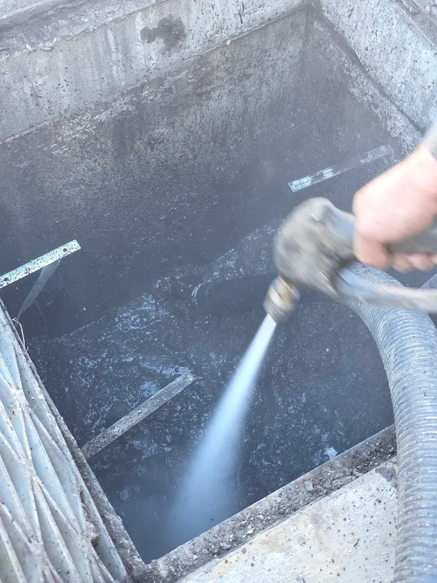 ASB Vac Services operator jetting a sludge-caked stormwater pit wall during cleaning