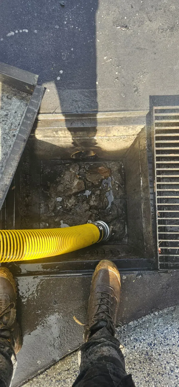 Wash bay pit loaded with grey sludge during ASB Vac Services cleanout