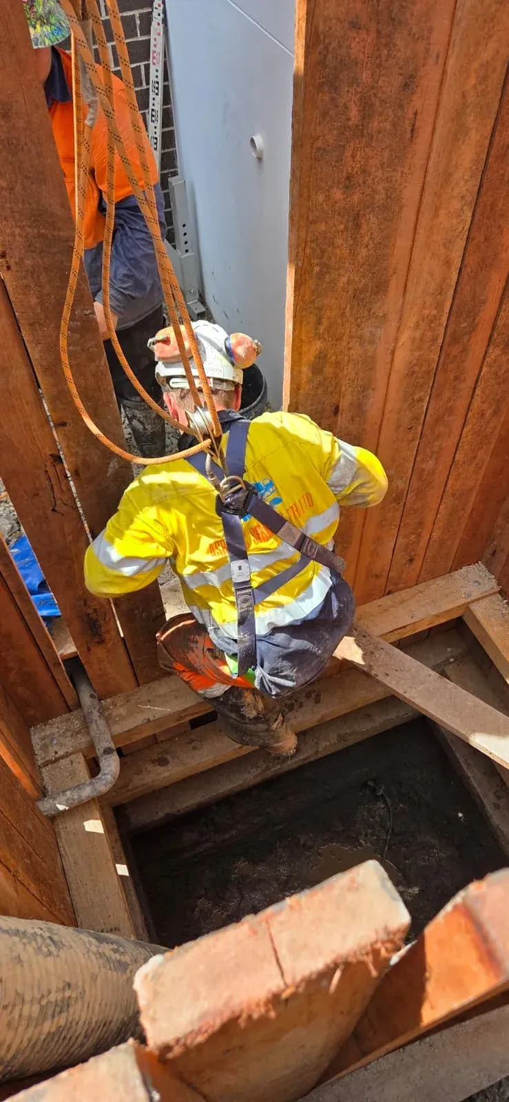 ASB Vac Services operator descending into a deep shored excavation